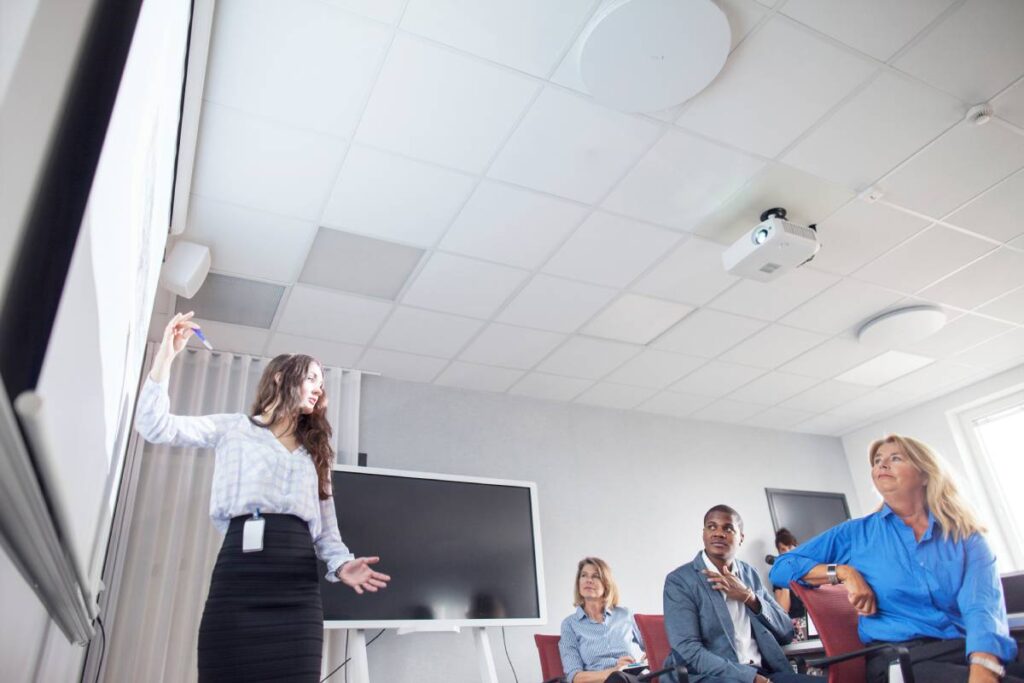 Confident woman presenting in a modern office meeting room.